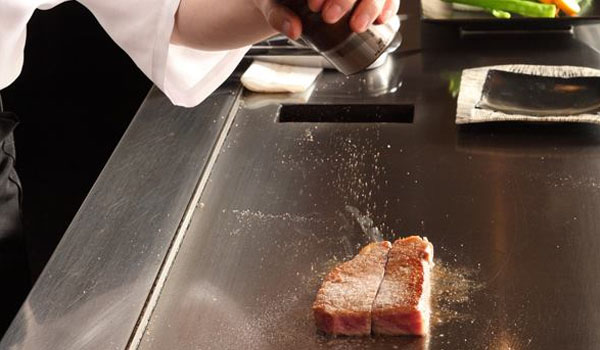 鉄板でステーキを焼く様子